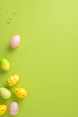 Dikey Paskalya yumurtaları yeşil bir zeminde yaratıcı bir şekilde sergileniyor, bayram neşesini çağrıştırıyor.