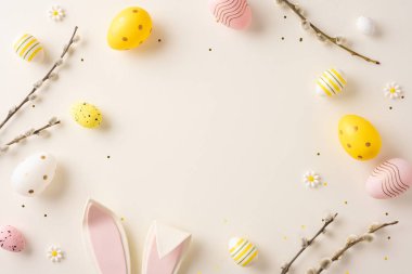 Paskalya yumurtaları, tavşan kulakları, söğüt dalları ve bahar kutlamaları için çiçekleri içeren dekoratif bir düzenleme.