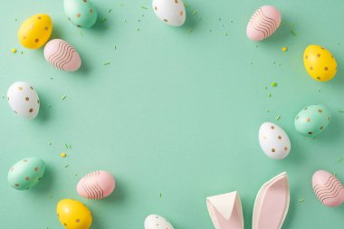 Renkli Paskalya yumurtaları puantiyeli ve çizgili, tavşan kulaklı.