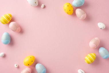 Dekoratif pastel renkli paskalya yumurtaları yumuşak pembe bir zemin üzerine dizilmiş bahar neşesi ve kutlamaları çağrıştırıyor. Tasarımlarınızı bu şenlikli ve neşeli kompozisyonla geliştirin