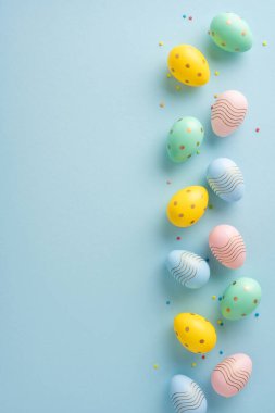 Paskalya dikey yumurtaları açık yeşil bir yüzeye yerleştirilmiş canlı pastel renkler ve desenler.