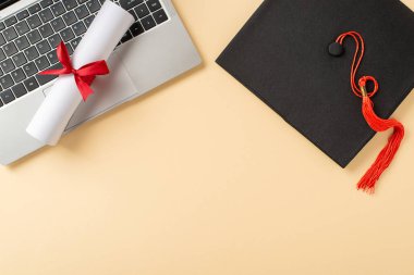 Mezuniyet eşyaları, püsküllü bir şapka, diploma ve dizüstü bilgisayar da dahil.