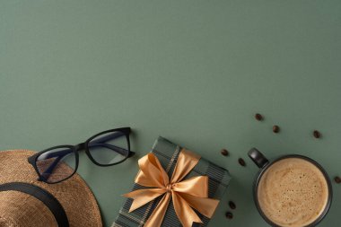 Yeşil arka planda fiyonklu hediye kutusu, kahve fincanı, bardak ve şapka.