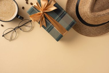 Süslü bir hediye kutusu, yanında kahve, bardak ve bej rengi şapka.