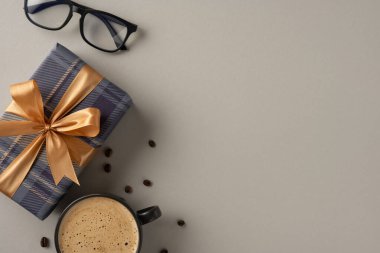 Çok güzel paketlenmiş bir hediye. Saten kurdelesi, kahve fincanı ve en az nötr arkaplanda gözlük. Özel günler için mükemmel bir görüntü, ilham verici hediyeler, ya da sıcak bir kutlama.