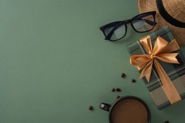 Yeşil arka planda yeşil kurdeleli, altın kurdeleli, kahve ve aksesuarlı bir hediye kutusu olan şık bir tatil düzeneği. Zarafeti, hediyeleri ve sıcak kahve anlarını iletmek için mükemmel..