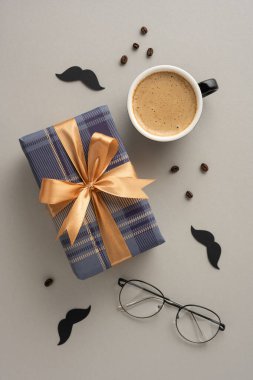 Altın kurdele, kahve fincanı, gözlük ve siyah bıyıklı şık dikey hediye kutusu Babalar Günü 'nü kutlamak için mükemmel.