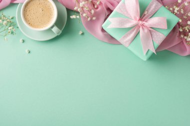 Yeşil kurdeleli yeşil bir hediye ve yumuşak yeşil bir arka planda kahve fincanı, festival ve karşılama temaları için mükemmel.