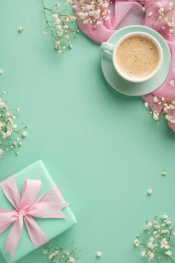 Yeşil ambalajlı bir hediye, bir fincan kahve, narin çiçekler ve pastel renkli bir arkaplan, bir kutlama duygusunu, düşünceli ve neşeli bir zarafeti çağrıştırıyor.