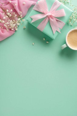 Hediye kutusu, kurdele, kahve fincanı ve çiçek aksanıyla pembe temalı dikey dekoratif daire.