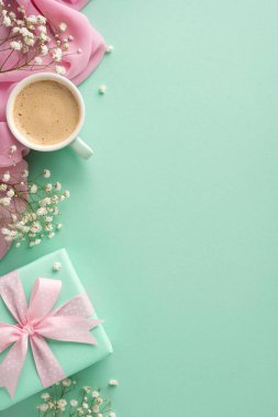 Bir kahve fincanı, narin çiçekler ve paketlenmiş bir hediyenin yer aldığı büyüleyici bir dikey kompozisyon. Anneler Günü, bahar kutlamaları ve hediye verme temaları için mükemmel.