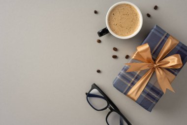 Tarafsız yüzeyde paketlenmiş bir hediye ve bardakların yanında nefis bir kahve fincanı.