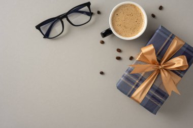 Gözlük ve hediye paketinin yanında bir fincan kahvenin olduğu rahat bir sahne.