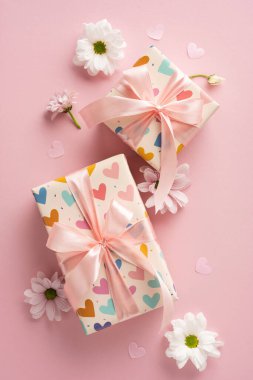 Taze beyaz papatyalar ve kalplerle süslenmiş pembe kurdelelerle süslenmiş hediyeler için harika dikey ambalajlar.