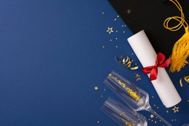 Diploma, şapka ve kutlama malzemelerinin yer aldığı yüksek açılı bir mezuniyet kurgusu. Tema, bu dönüm noktasında başarılar ve sevinç sergiliyor