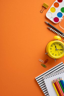 Okul düşey kırtasiyesi ve sanat araçları turuncu bir arkaplanda eğitim ve yaratıcılık aktarımı için düzenlenmiştir.