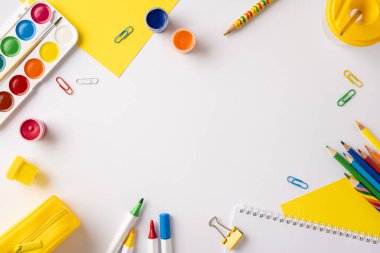 Çeşitli canlı okul malzemelerinin sanatsal düz konumu. Pastel boyalar, boyalar ve defterler dahil. Yaratıcılığa ilham verici.