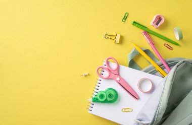 Makas, kalem ve not defteri gibi çeşitli okul malzemelerinden oluşan bir koleksiyon, sarı bir arkaplanda yaratıcı bir şekilde resmedilmiştir. Organizasyon, eğitim ve akademik çalışmalara hazırlık sunar