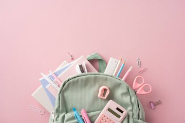 Sırt çantasından çıkan kalem, cetvel ve makas içeren düzgün bir kırtasiye düzeni