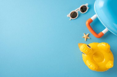 Yaz yolculuklarının ve plaj aksesuarlarının en üst görüntüsü. Mavi renkte güneş gözlüğü ve şamandıra da dahil.