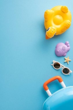 Renkli dikey yaz temalı seyahat gereksinimleri arasında şişirilebilir oyuncaklar, güneş gözlükleri ve mavi arka planda valiz