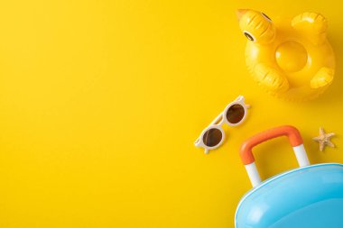 Güneş gözlüğü, şişirilebilir yüzük, bavul ve deniz yıldızı gibi seyahat gereksinimlerinin düz bir görüntüsü vardı. Yaz tatilini ve plaj rahatlığını vurguluyordu..