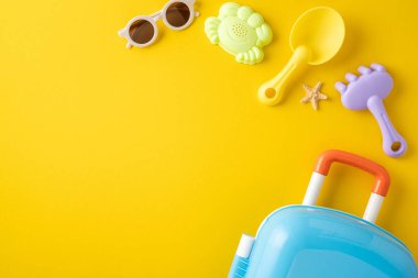 Parlak sarı arka planda bavul, güneş gözlüğü ve renkli plaj oyuncakları, yaz yolculukları ve plaj eğlencelerini çağrıştırıyor.