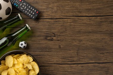 Atıştırmalıklar, içkiler ve futbol temalı bir dekorla oyun gecesi için hazır bir ortam.