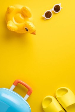 Şamandıra, güneş gözlüğü ve bavul da dahil olmak üzere seyahat ve yaz öğelerini içeren parlak dikey görüntü, bayram atmosferini çağrıştırıyor