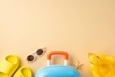 Yaz tatilinde şişme oyuncaklar, bavullar ve sandaletler gibi plaj eşyalarının kullanıldığı seyahat gereksinimleri.