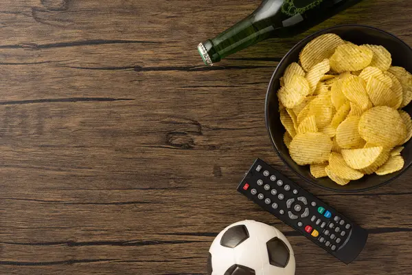 Bir kase cips, bira şişesi, uzaktan kumanda ve futbol topu boş zamanları ve heyecanı yakalar.