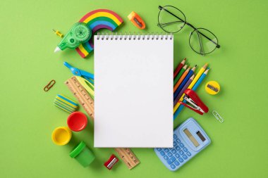 Okul eşyaları arasında boş bir defter, kalemler, cetvel ve boyalar da var.