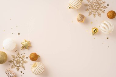 Mücevherler, yıldızlar ve kar taneleri gibi altın dekorlar bej bej bir yüzeyde parıltılarla süslenmiş zarif bir tatil ortamı yaratıyor.