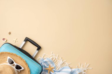 Bavul, hasır şapka, güneş gözlüğü ve deniz kabuklarından oluşan bej arka planda yaz seyahati öğeleri bir tatil teması ve rahat bir atmosfer sergiliyor