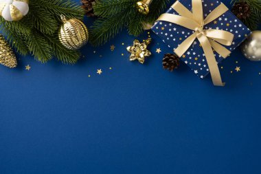 Hediye kutusu ve mavi arka planda süsler de dahil olmak üzere Noel süslemeleri için şenlikli bir düzenleme