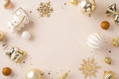 Tarafsız bir bej arkaplan üzerine zarif bir şekilde yerleştirilmiş altın ve beyaz Noel süsleri, bayram teması ya da festival projeleri için mükemmel