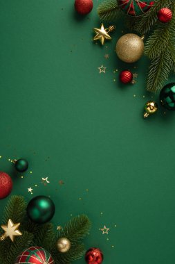 Noel süsleri, mücevherler ve yıldızlar da dahil olmak üzere, çam dalları ve parıltılı aksanlı yeşil bir zemin üzerine yerleştirilmiş, bayram ruhunu ve mevsimsel neşeyi çağrıştıran.