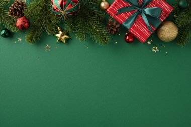 Bayram temalı kompozisyonda süsler, yemyeşil dallar ve yeşil arka planda sarılı bir hediye kutusu, neşeli, kutlayıcı bir atmosfer taşır.