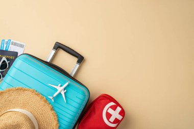 Seyahat gereksinimleri bej bir yüzeye yerleştirildi. İçinde bavul, pasaport ve sağlık malzemeleri vardı.