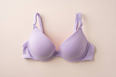 Bej bir yüzeyde gösterilen zarif mor sütyen zarafet ve işlevselliği vurgular