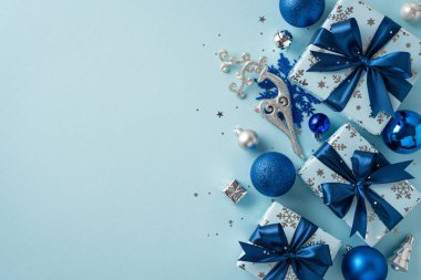 Mavi ve gümüşten oluşan bayram renklerinde güzel bir hediye ve Noel süsleri düzenlemesi, bayram sezonu için neşe ve kutlama havası yaratıyor.