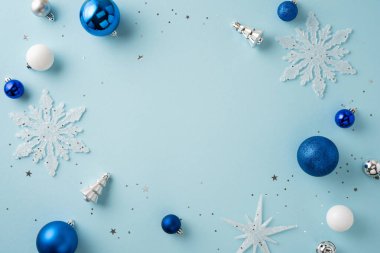 Mavi ve beyaz Noel süslemeleri, tatil sanatı için arka planda yaratıcı bir şekilde düzenlenmiştir.