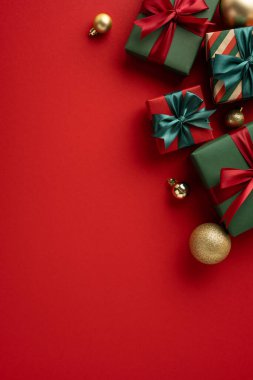 Canlı kırmızı bir yüzeye yerleştirilmiş hediye ve süslemelerle dolu güzel bir şenlik sahnesi.