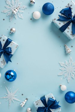 Şenlikli dikey mavi ve gümüş süsler, süsler ve paketlenmiş hediyeler mevsimlik tatil havası yaratıyor.