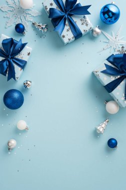 Mavi palette paketlenmiş hediyeler, süsler ve şenlikli dekorasyonlar içeren bayram temalı dikey kompozisyon