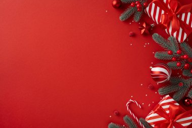 Vibrant red holiday scene featuring pine branches, red ornaments, candy canes, and striped gifts ready for Christmas and New Year greetings