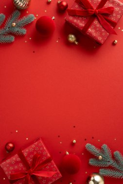 Red vertical themed Christmas scene featuring wrapped gifts, ornaments, pine branches and twinkling decorations evokes festive mood and warm holiday greeting