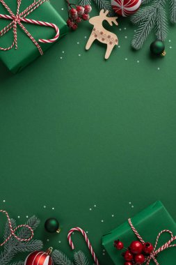 Sarılı hediyeler, çizgili ip, tahta ren geyiği, çam dalları, böğürtlenler, süsler ve şeker kamışlarıyla yeşil dikey arkaplan.