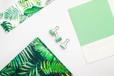 Monstera designed stationery is laying on the table, metal clasp, paper clip, green color