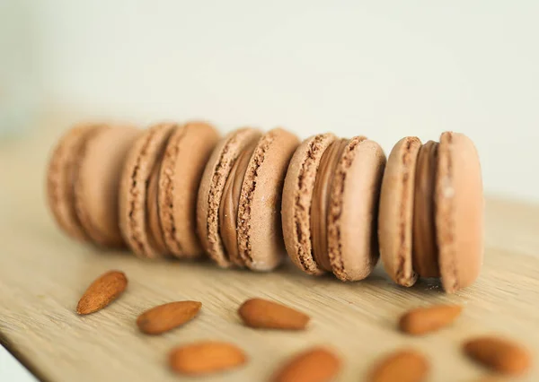 Stock image Delicious chocolate macaroons with almonds on a wooden table